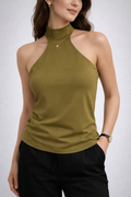 Female model wearing a green sleeveless blouse.