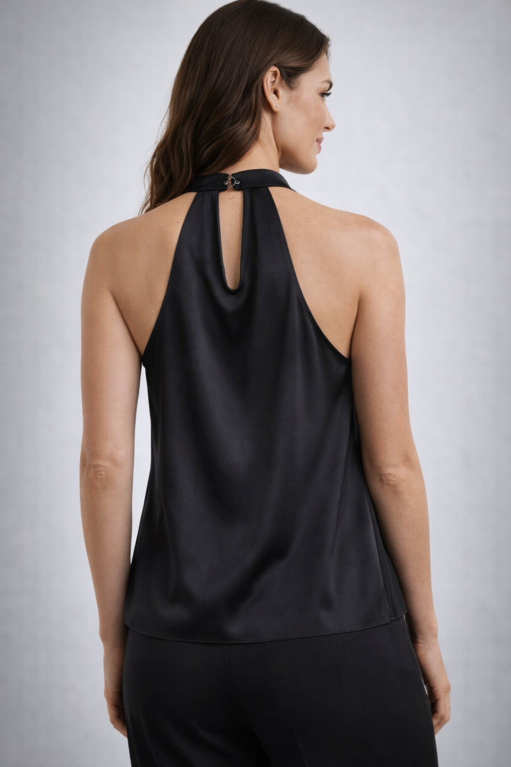 Female model wears a sleeveless black blouse on a gray background.